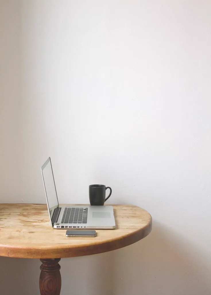 Ambiente de trabalho para terapia online - laptop e xícara em mesa de madeira